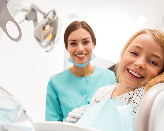 Little girl smiling at dentist’s office and receiving dental crowns in Hamilton