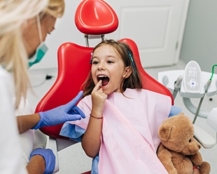 Little girl pointing to her mouth and smiling