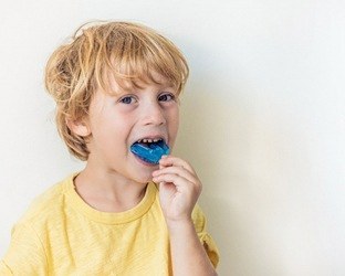 Little boy putting in a customized mouthguard