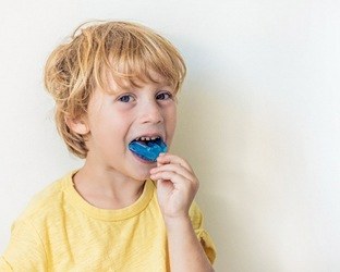 Little boy putting in a customized mouthguard
