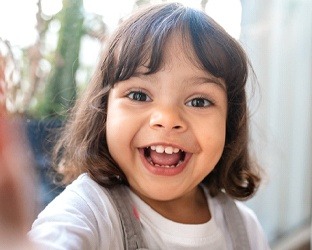 Little girl smiling while playing around house