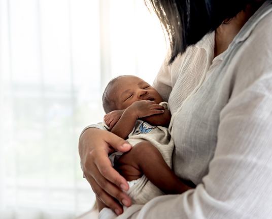 mom holding a baby after a laser frenectomy in Hamilton 