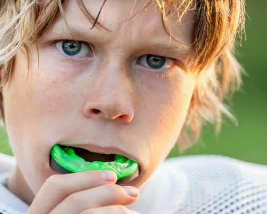 Teen placing an athletic mouthguard