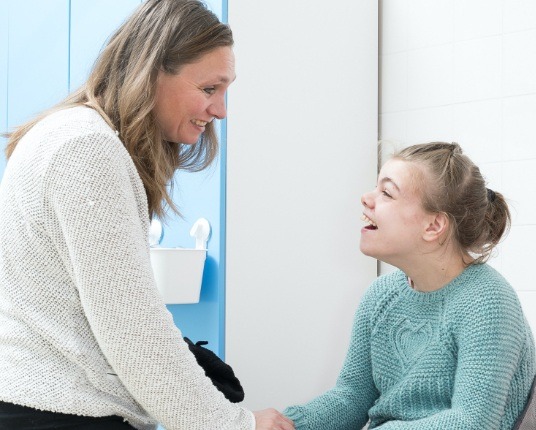 Young girl smiling at dentist during special needs dentistry visit