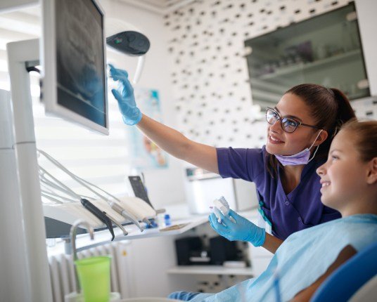 Dentist and child looking at digital x-rays