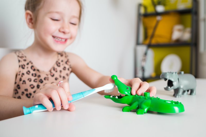 child brushing gator’s teeth